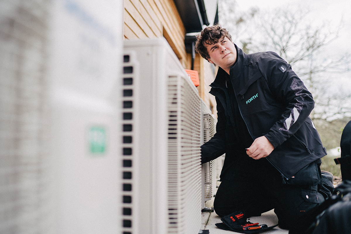 A FORTH® engineer works on some outside air conditioning equipment