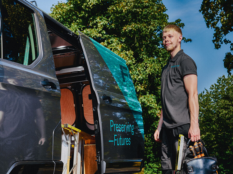 A young FORTH® engineer carrying his tools stands proudly next to his van.